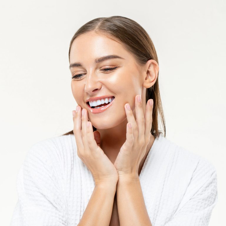 Smiling,Beautiful,Caucasian,Woman,Touching,Her,Face,On,Isolated,Studio